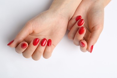 Woman with red polish on nails on white background, closeup
