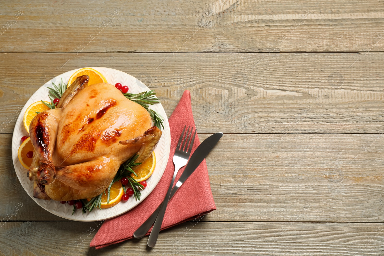 Photo of Delicious cooked turkey served on wooden table, flat lay with space for text. Thanksgiving Day celebration