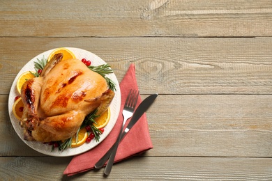 Photo of Delicious cooked turkey served on wooden table, flat lay with space for text. Thanksgiving Day celebration