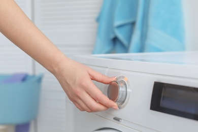 Photo of Young woman doing laundry at home, closeup