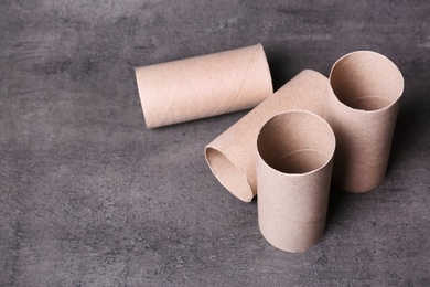 Photo of Empty toilet paper rolls and space for text on gray background