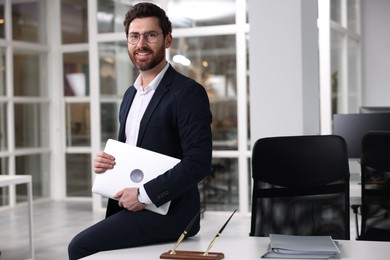 Photo of Portrait of smiling man with laptop in office, space for text. Lawyer, businessman, accountant or manager