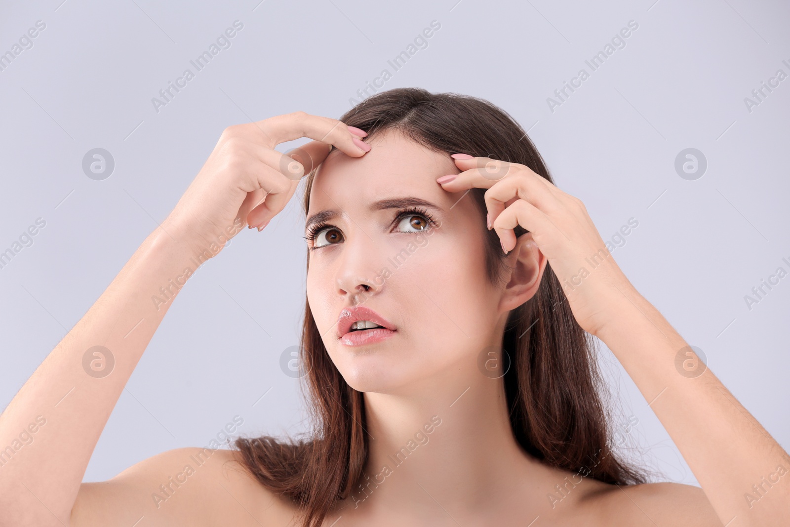 Photo of Teenage girl with acne problem against grey background
