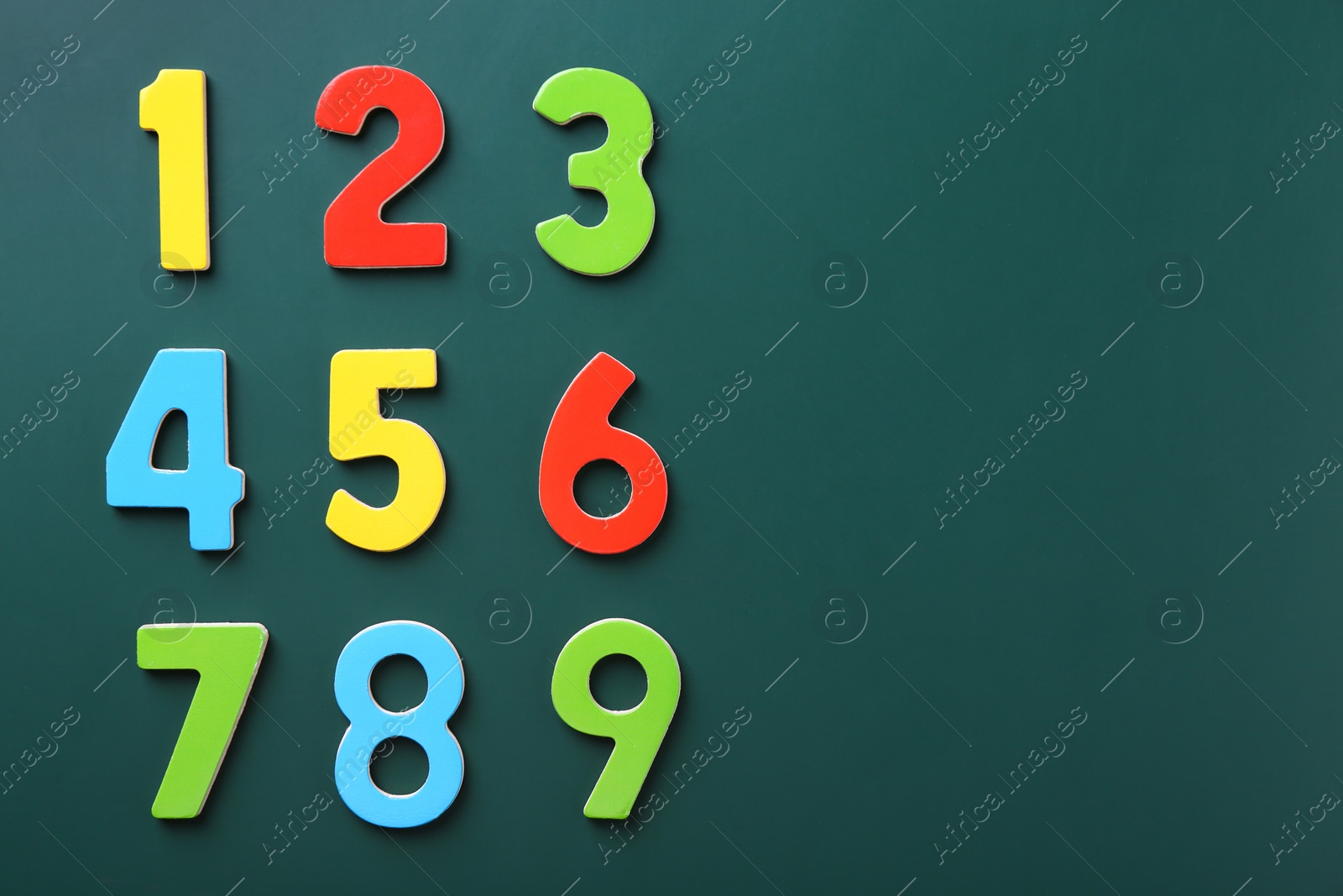 Photo of Colorful numbers on green background, flat lay. Space for text