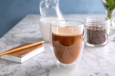 Photo of Glass of aromatic hot coffee on marble table
