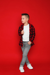 Photo of Full length portrait of cute little boy on red background