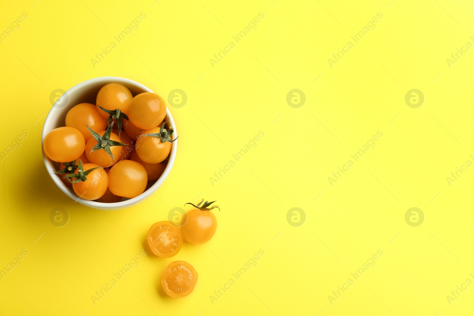 Photo of Yellow tomatoes on color background, flat lay. Space for text