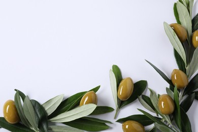 Photo of Fresh green olives and leaves on white background, flat lay. Space for text