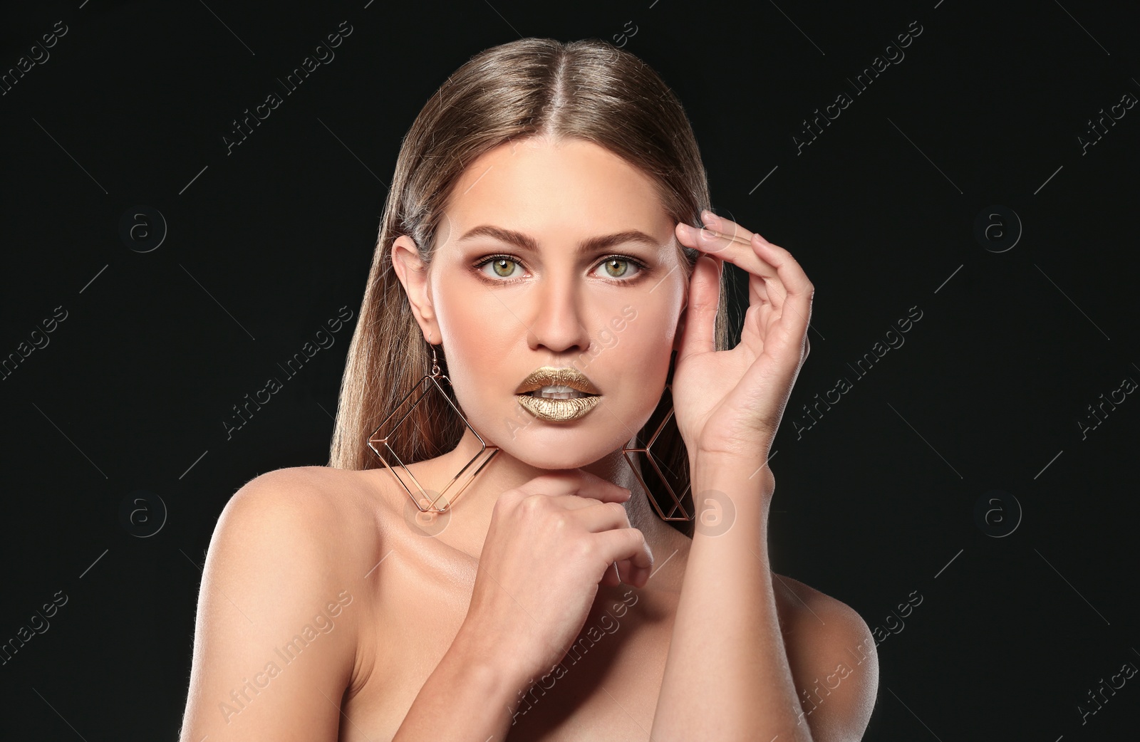 Photo of Portrait of beautiful lady with gold lipstick on black background