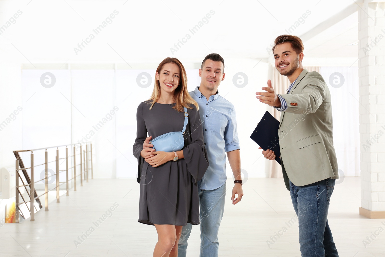 Photo of Real estate agent showing new apartment to young couple