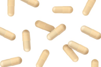 Image of Vitamin. Many capsules falling on white background