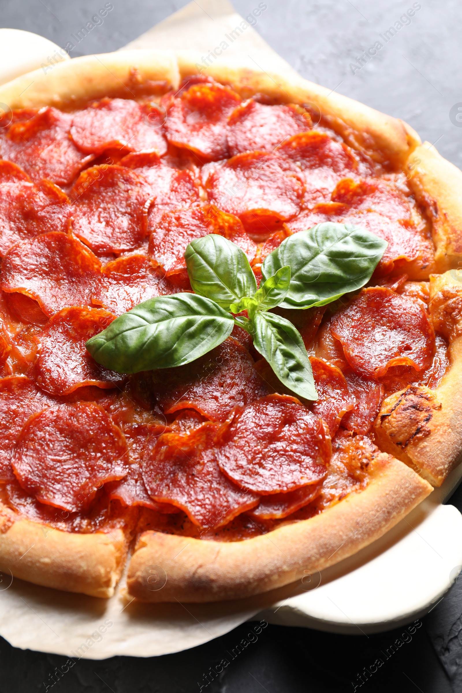 Photo of Tasty pepperoni pizza on dark grey table, closeup