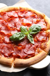 Photo of Tasty pepperoni pizza on dark grey table, closeup