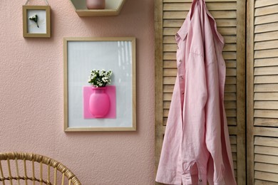 Photo of Silicone vase with beautiful white flowers on pink wall in room