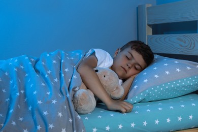Photo of Cute little boy sleeping with teddy bear at home. Bedtime