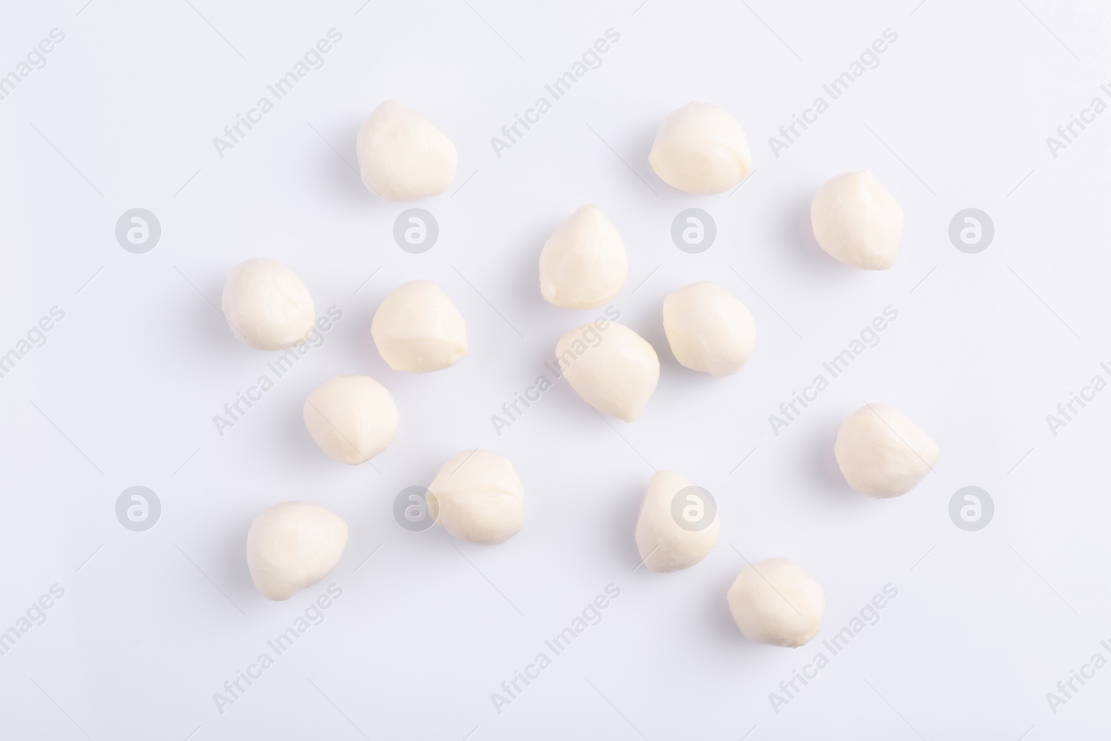 Photo of Tasty mozzarella balls on white background, flat lay
