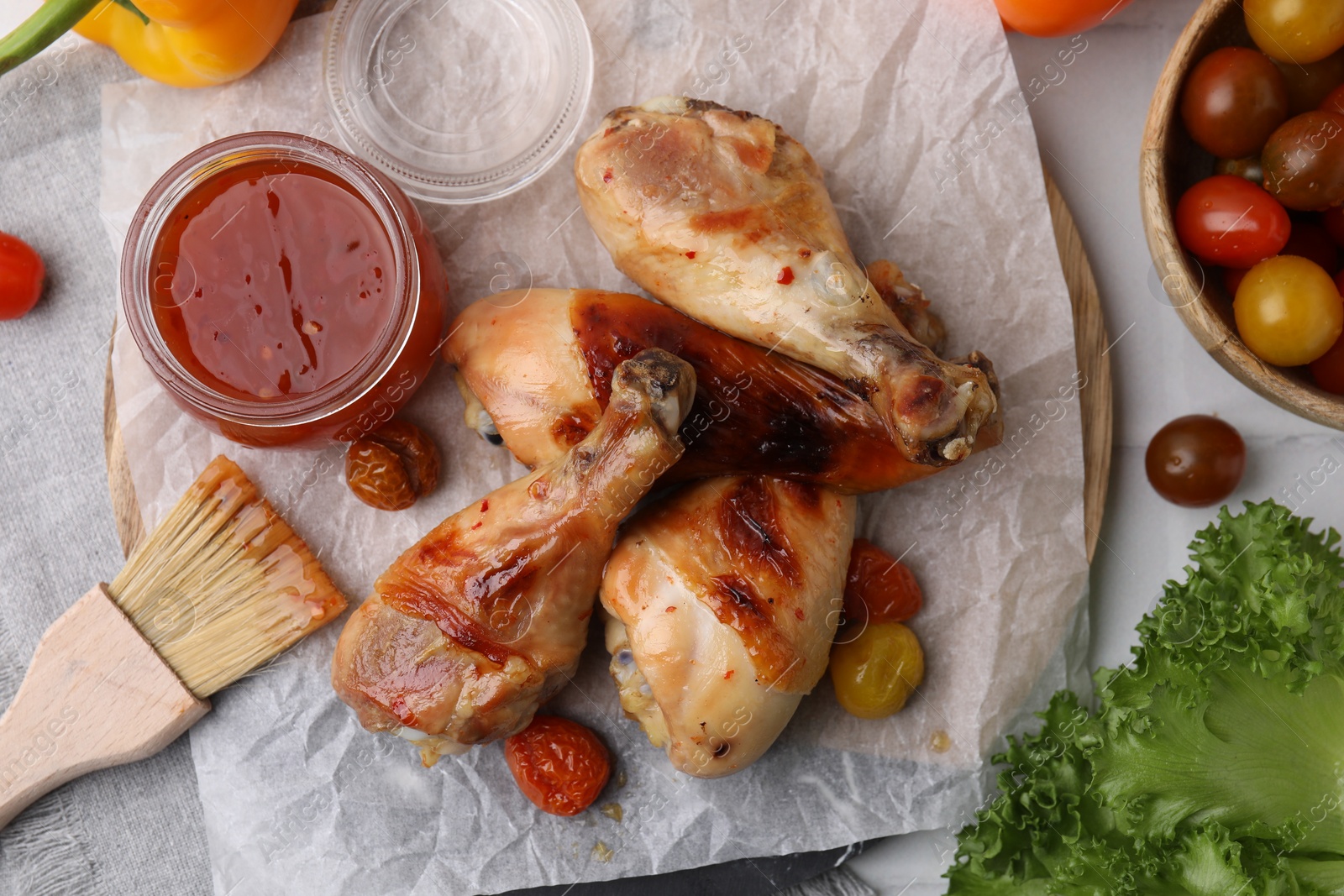 Photo of Flat lay composition with marinade and roasted chicken drumsticks on white table