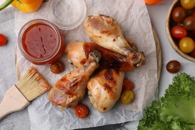 Photo of Flat lay composition with marinade and roasted chicken drumsticks on white table