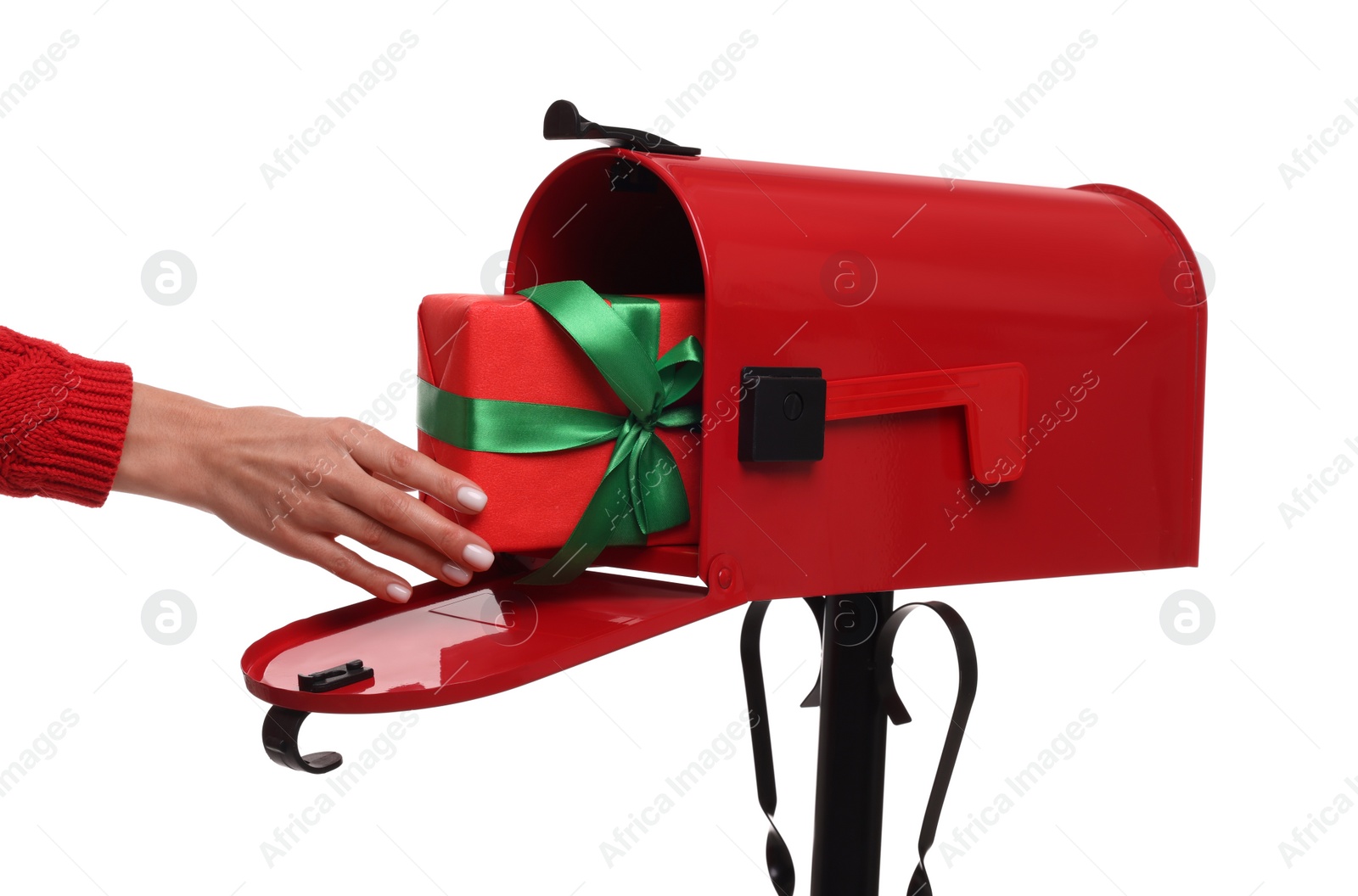 Photo of Woman putting Christmas gift into mailbox on white background, closeup. Sending present by mail