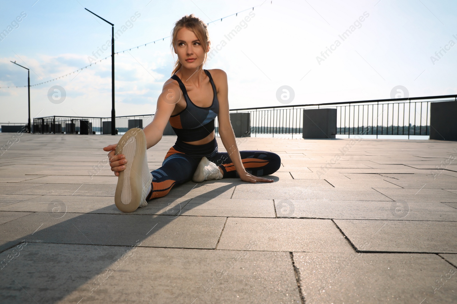 Photo of Beautiful woman in sportswear doing exercises outdoors on sunny day