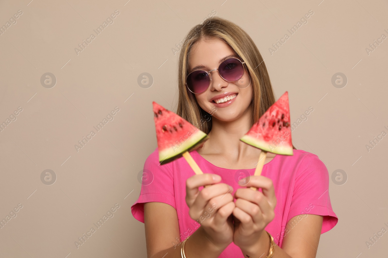 Photo of Beautiful girl with pieces of watermelon on beige background. Space for text