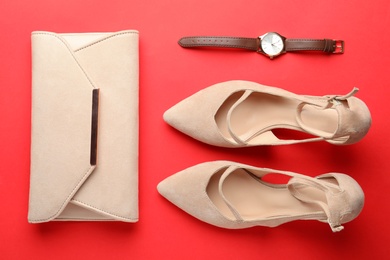 Photo of Flat lay composition with stylish women's shoes and accessories on red background