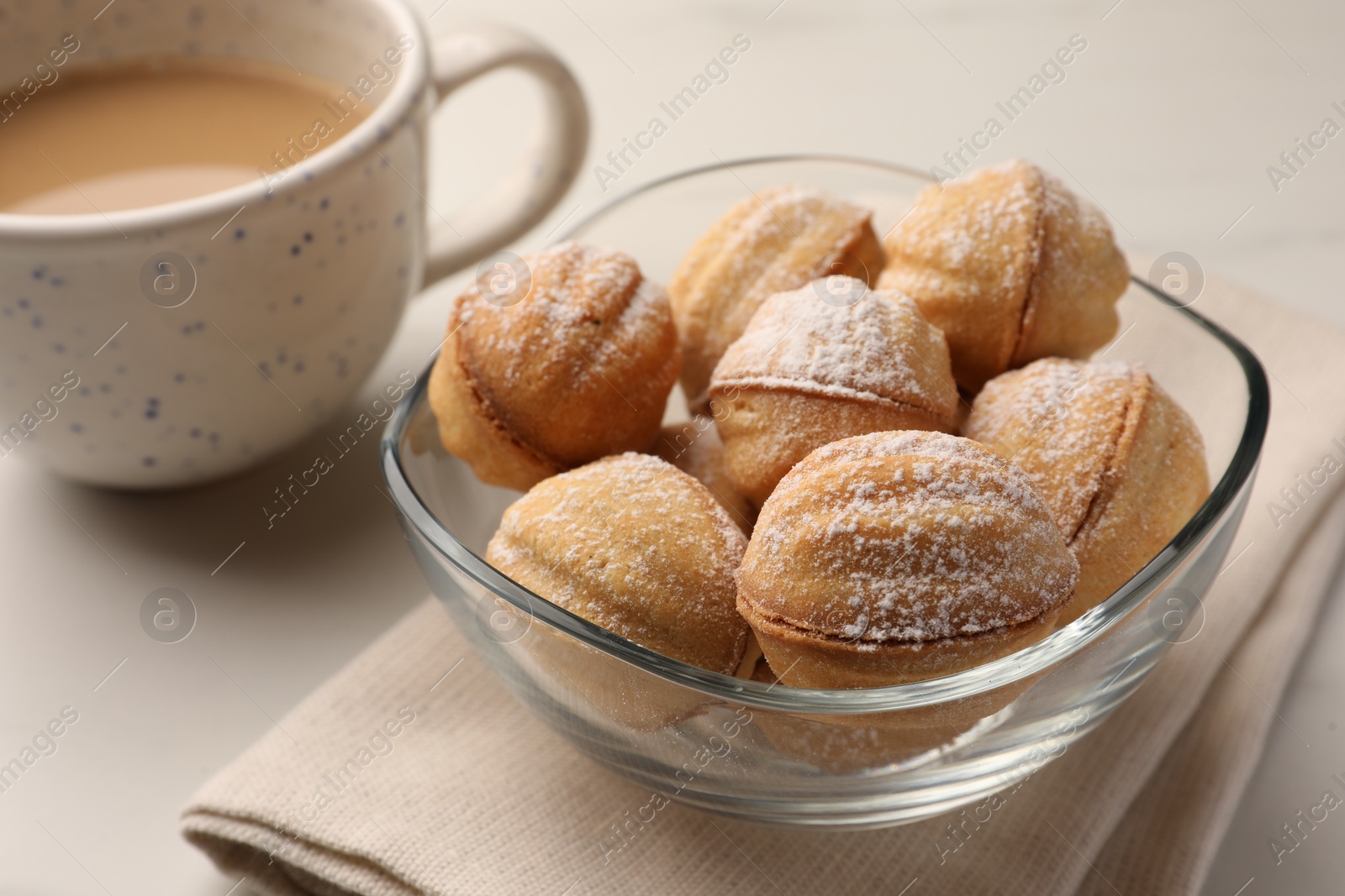 Photo of Homemade walnut shaped cookies with condensed milk and coffee on white marble table, closeup