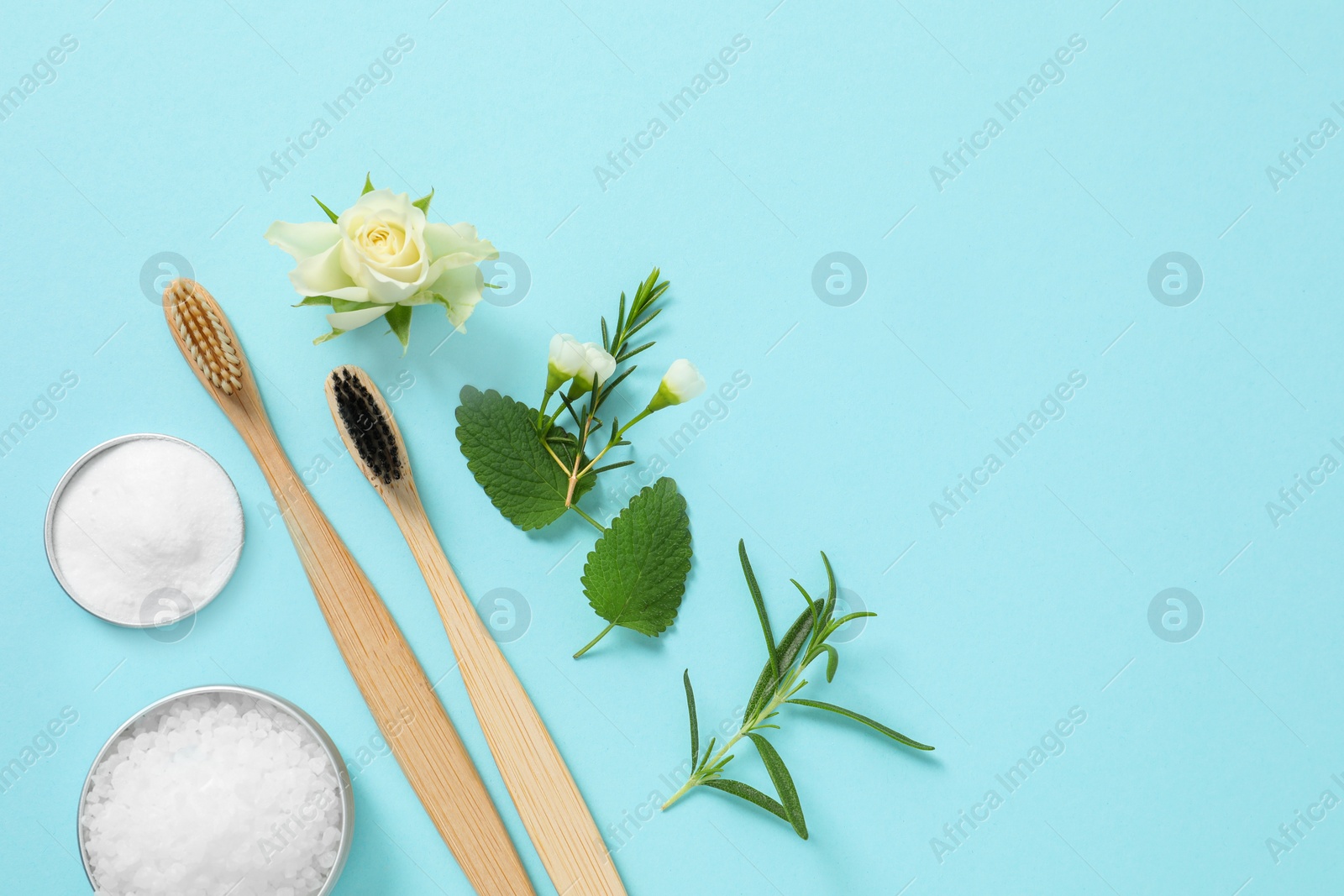 Photo of Flat lay composition with toothbrushes and herbs on turquoise background. Space for text