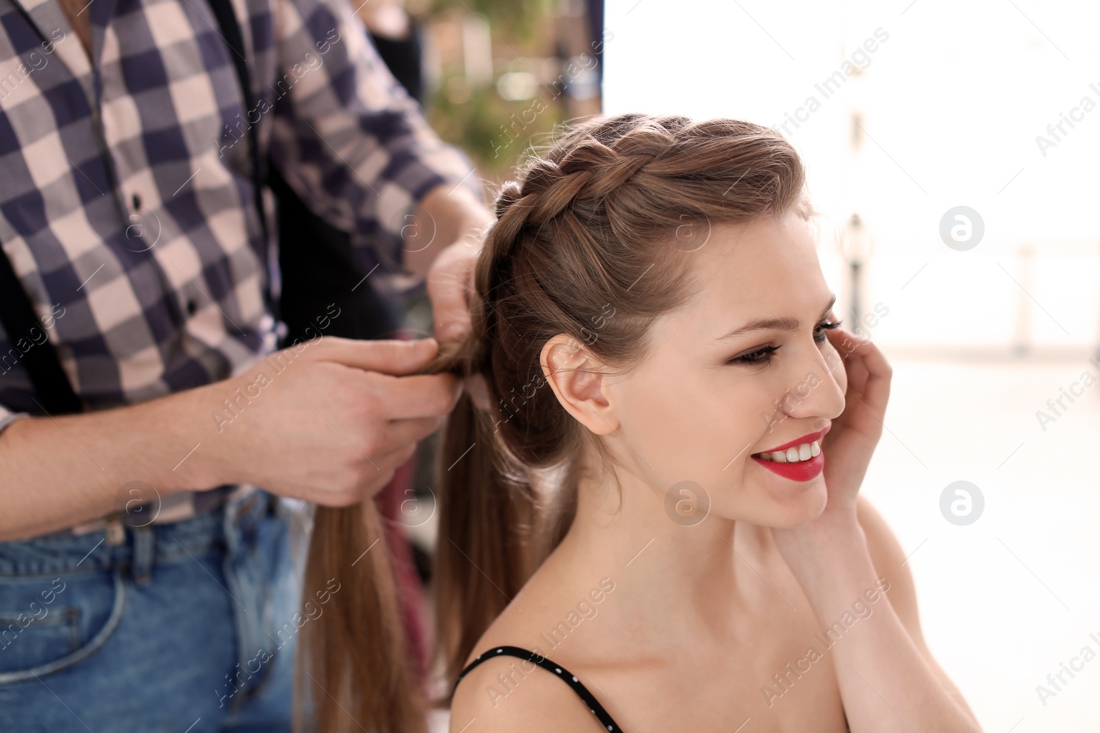 Photo of Professional hairdresser working with client in beauty salon