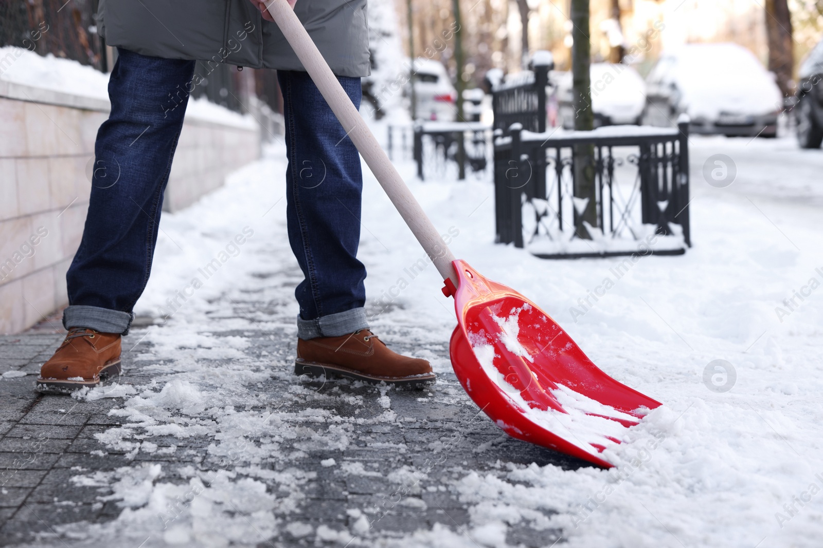 Photo of Man shoveling snow on city street, closeup