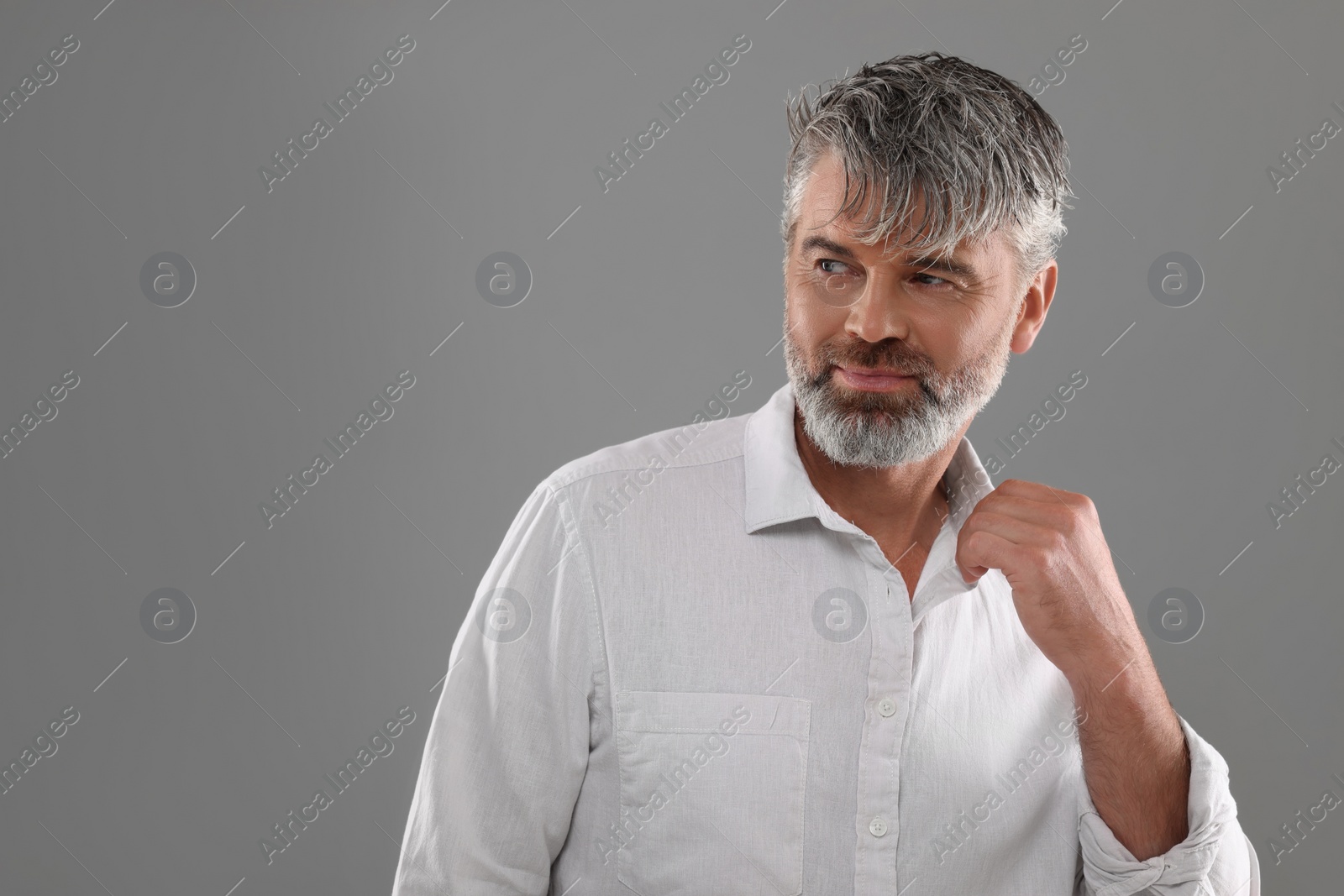 Photo of Portrait of confident man with beautiful hairstyle on light grey background. Space for text