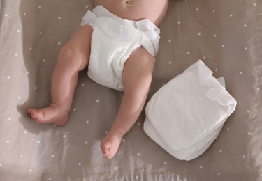 Photo of Cute little baby in diaper on changing table, top view
