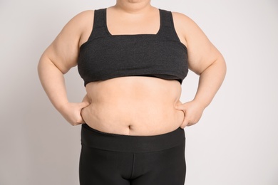 Overweight woman on light background