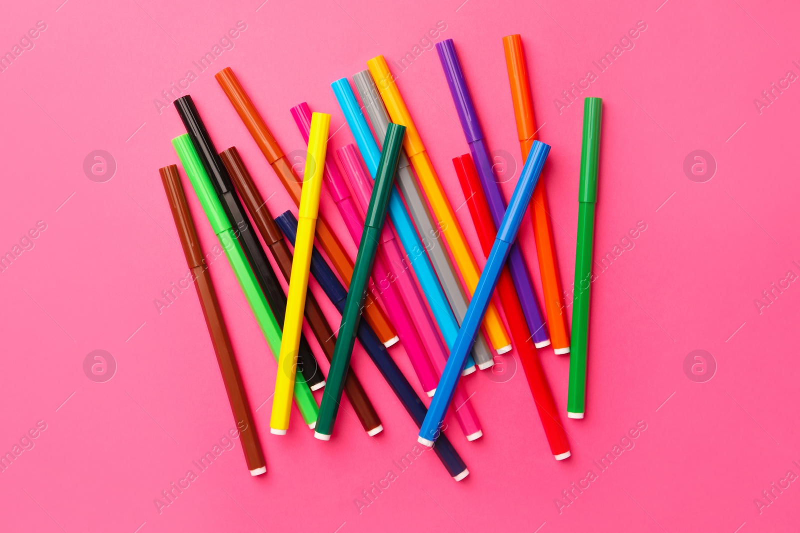 Photo of Many bright markers on pink background, flat lay