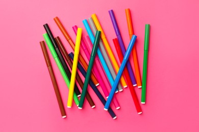 Photo of Many bright markers on pink background, flat lay