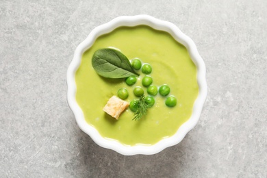 Photo of Fresh vegetable detox soup made of green peas and spinach in dish on table, top view