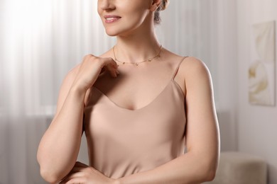 Woman with elegant necklace on blurred background, closeup