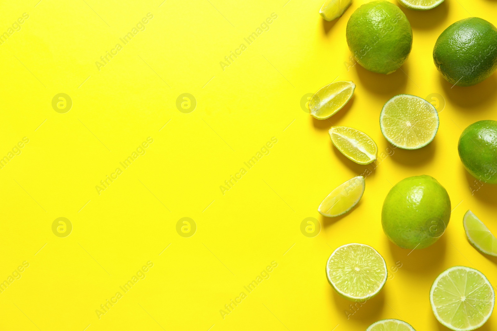 Photo of Fresh limes on color background, flat lay with space for text. Citrus fruits