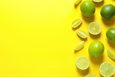 Fresh limes on color background, flat lay with space for text. Citrus fruits