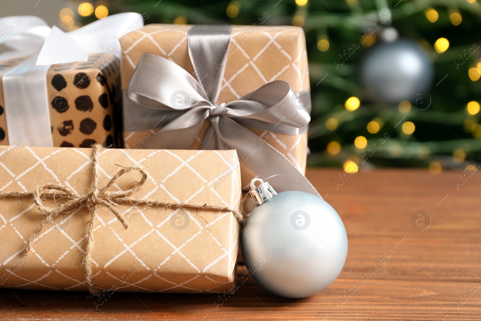 Photo of Beautiful gift boxes and blurred Christmas tree on background