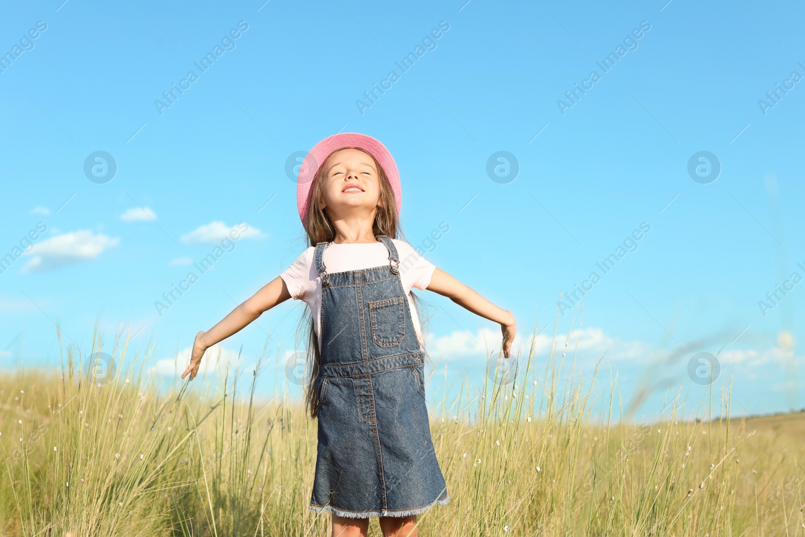 Photo of Cute little girl outdoors on sunny day. Child spending time in nature