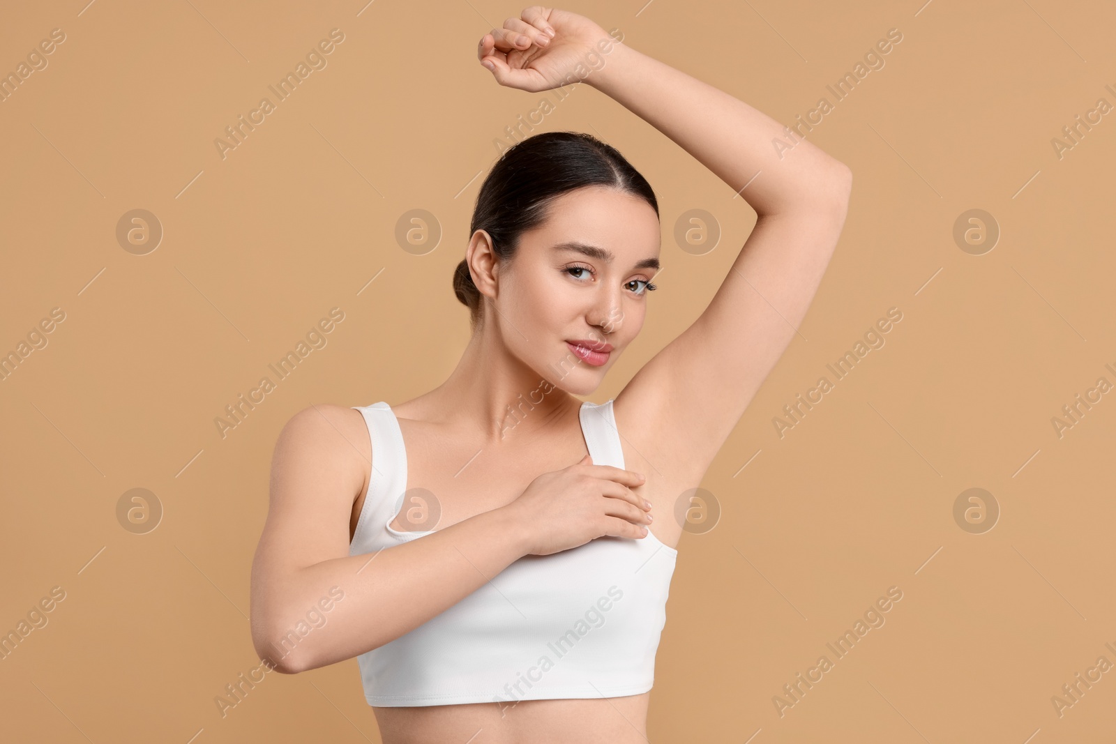 Photo of Beautiful woman showing armpit with smooth clean skin on beige background