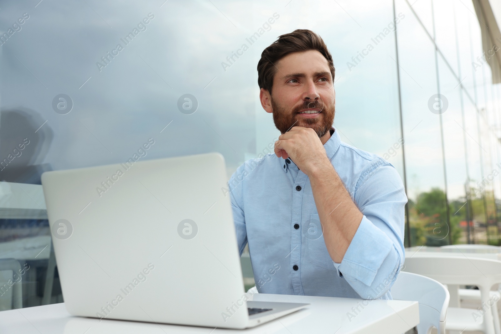 Photo of Handsome man with laptop in outdoor cafe