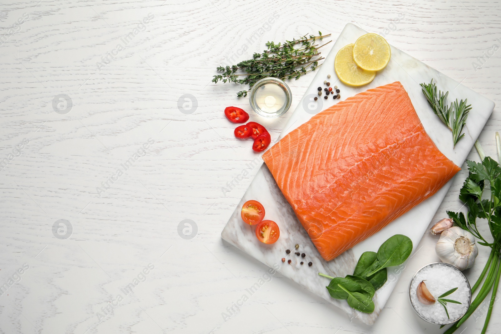 Photo of Fresh raw salmon and ingredients for marinade on white wooden table, flat lay. Space for text