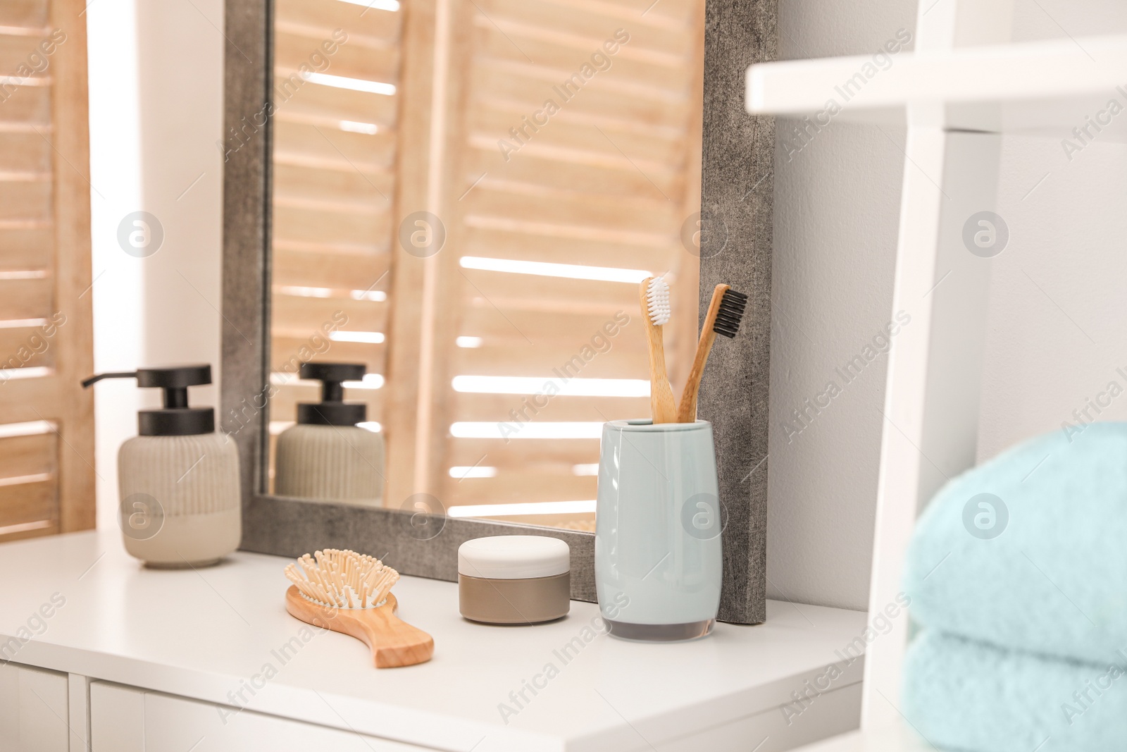 Photo of Different toiletries near mirror in modern bathroom