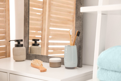 Photo of Different toiletries near mirror in modern bathroom