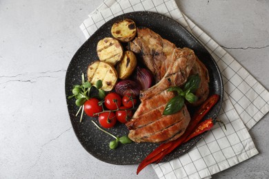 Delicious grilled meat and vegetables on light grey table, top view