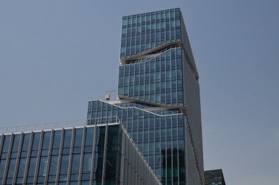 Exterior of beautiful modern skyscraper against blue sky