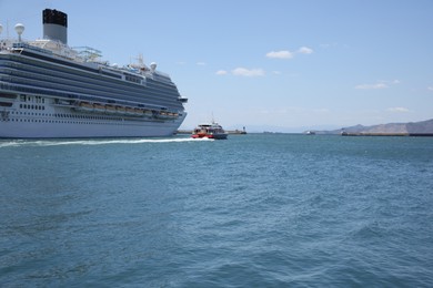 Photo of Modern cruise ship and boat in sea on sunny day