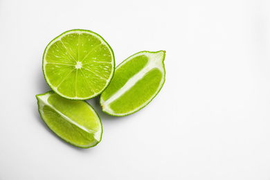 Photo of Cut fresh juicy limes on white background, top view